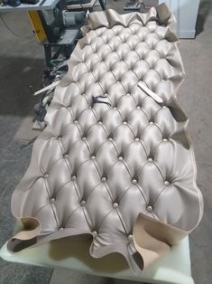 an upholstered bench being worked on in a factory