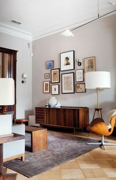 a living room filled with furniture and framed pictures on the wall above an entertainment center