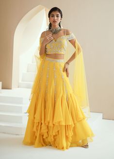 Editor's Note Embellished Off Shoulder Choli Paired With An Asymmetrical Skirt And Scalloped Dupatta Fabric: Choli- Georgette, Skirt- Organza, Dupatta- Net Color: Yellow Embroidery Details: Hand Embroidery With Pearls, Glass Beads And White Beads. Care: Dry Clean Only About the Designer Seema Thukral collection offers glamorous, elegant, and chic clothing for women. It consists of drapes with intricate handwork and embroideries. The brand forte is all about different and unique cuts that involve Yellow Choli, Fashion Show Dresses, Yellow Embroidery, Yellow Lehenga, Printed Peplum Top, Ethnic Outfits, Wedding Dresses For Girls, Stylish Sarees, Indian Wedding Outfits