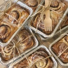 several trays filled with cinnamon rolls on top of a table