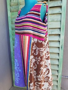 a colorful towel is hanging on a clothes rack in front of a shuttered window