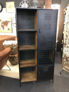 a tall black cabinet sitting next to a brown chair