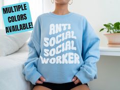 "Show off your sense of humor with this hilarious Anti Social Social Worker sweatshirt! This hilarious design features a play on words that will make all your friends and coworkers laugh. Made of soft, comfortable fabric, this stylish sweatshirt is perfect for any social worker who has a great sense of humor. You're sure to get plenty of laughs with this funny, retro style design.  *Please note the color name options listed with the corresponding picture *We recommend sizing up 1 - 2 sizes for the oversized look seen in the photos* (see size chart for details). Our sweatshirts are nice and cozy without being too heavy. All sweatshirts are machine wash and dryable! If you like what you see and are interested in more social work apparel/gifts, check out the \"Professions/Careers\" section of Cotton Sweatshirt With Funny Text, Funny Slogan Sweatshirt In Relaxed Fit, Funny Text Relaxed Fit Sweatshirt, Relaxed Fit Crew Neck Sweatshirt With Funny Text, Social Worker Graduation, Social Work Shirt, Social Work Humor, Social Worker Gifts, Word Play