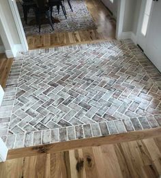 a room with wood floors and tile flooring in the middle of it is shown