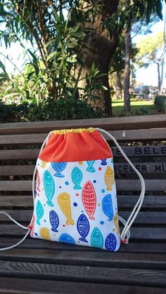 a drawstring bag sitting on top of a wooden bench