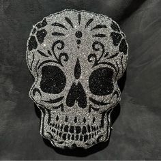 a silver and black sugar skull on a black background