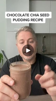 a man holding a jar filled with chocolate chia seed pudding and pointing to it