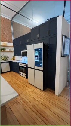 a kitchen with black and white cabinets, wood floors and an oven in the center