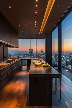 a kitchen with wooden floors and large windows overlooking the cityscape at night time