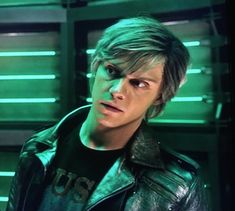 a young man in a leather jacket looking at the camera with an intense look on his face