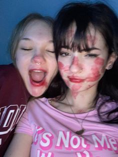 two girls with their faces painted red and white