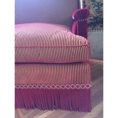 a pink chair with fringe trim on it