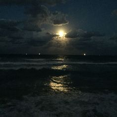 the moon is shining brightly over the ocean