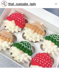 decorated cupcakes in a white box on a table