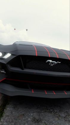 the front end of a black mustang with red stripes