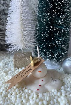 a small snowman with a name tag on it