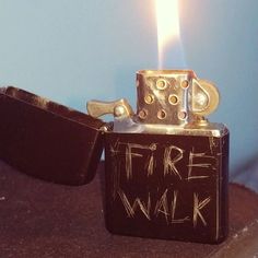 a lighter with the word free walk written on it and a lit candle in the background