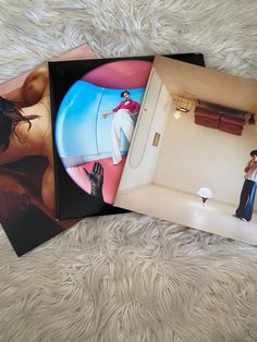 three books with pictures of women on them sitting on top of a white carpeted floor