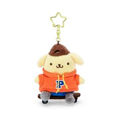 a key chain with a stuffed animal wearing an orange shirt and brown hat on it