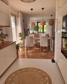 an open kitchen and dining room with wood flooring, white walls and wooden floors