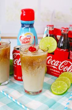 two glasses filled with soda and limes on top of a table