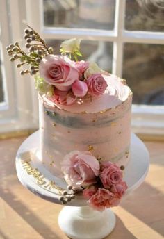 a three tiered cake with pink flowers on top