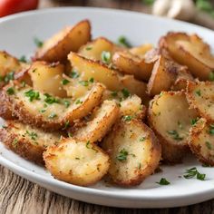 a white plate topped with fried potatoes on top of a wooden table