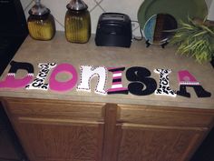 a kitchen counter with the word ponsea spelled in black, pink and white