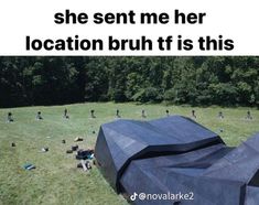 there is a large black tent in the middle of a field