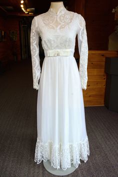 A beautiful 1980's wedding gown made of light weight fabric. Lace bodice, trim and long sleeves. Adorned with a silk bow on the waist and a classic high neck.  Size - 6 to 8 Dress length - 56.5 in Bust - 33.5 in Waist - 25.4 in How it closes - Zipper back White Long Sleeve Victorian Dress For Formal Occasions, Bohemian Belts, Fall Necklaces, Dresses Business, Formal Fashion Women, Fall Night, White Bridal Shower, Fashion Formal, Fashion Modest