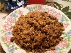 a white plate topped with rice and beans on top of a floral design table cloth