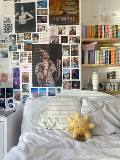 a bed with a stuffed animal sitting on top of it next to a book shelf filled with books