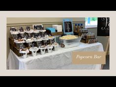 a table topped with lots of food next to a sign that says popcorn bar on it