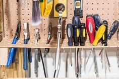 the tools are hanging on the pegboard in the garage, ready to be used