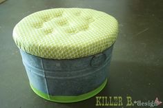 a green and gray bucket sitting on top of a table