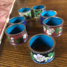 six blue and red cups sitting on top of a wooden table