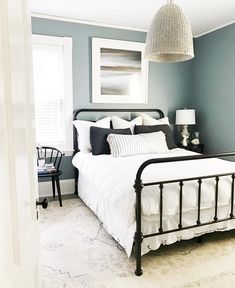 a bedroom with blue walls and white bedding