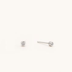 "Sold as a pair.  A jewelry box staple. These genuine sterling silver bezel stud earrings are a simple must-have, featuring the brilliant AAA grade cubic zirconia this contemporary design bezel set is perfect for your everyday life. The perfect accessory to go with any outfit, these sparkling CZ stones will glimmer on every side in all your photos. The blingy tiny studs are beautiful and affordable, you can buy them with confidence knowing that you can wear them for any occasion. It is great for daily wear such as jeans & t-shirts to dressy outfits like business suits and evening gowns. This retro-glam stud earring will be classier if you pair them with a cool tee and denim jacket together. Selection from 2mm, 3mm, and 4mm for multi-pierced women, men, or children, and for those who have m Minimalist Sterling Silver Earrings With Single Diamond, Minimalist Everyday Earrings With Bezel Setting, Everyday Minimalist Earrings With Bezel Setting, Silver Minimalist Birthstone Earrings, Minimalist Bezel Set Earrings, Tiny Classic Silver Earrings, Tiny Silver Classic Earrings, Minimalist Round Earrings With Bezel Setting, Minimalist Silver Earrings With Bezel Setting