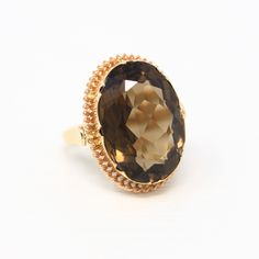 Stylish vintage circa 1970s era retro 14k yellow gold genuine smoky quartz ring! This incredible statement ring features an oval faceted genuine 13.01 carat smoky quartz gemstone. The coffee brown gem is securely bezel set, and there is a unique scalloped border. A gorgeous piece of fine vintage jewelry, featuring a stunning genuine gemstone!  *Sale - price reduced from $695 USD to $675 USD.  ERA - Circa 1970s - Retro METAL / MATERIAL - 14k yellow gold, genuine smoky quartz (approx. 13.01 CT) MARKINGS / HISTORY - There are no markings but the piece has been professionally tested.   CONDITION - Good vintage condition. Yellow gold metal has been professionally polished & cleaned. Genuine smoky quartz is secure. Amazing genuine gemstone ring!  SIZE / MEASUREMENTS - Size: 5 1/4, Ring Head Heig 70s Jewelry, Scalloped Border, Smoky Quartz Ring, Logo Gifts, Retro Jewelry, Ruby Stone, Coffee Brown, Platinum Ring, Quartz Ring