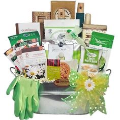 the garden gift basket is filled with gardening related items and includes gloves, soaps, tea bags, cookies, seed packets, cards, and more