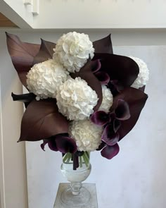 a vase filled with white and purple flowers