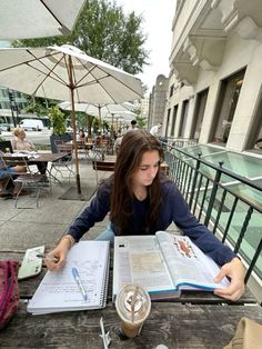 a woman sitting at a table with an open book