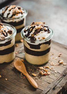 three desserts in glass jars on a wooden table