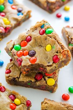 several cookies and candy bars are stacked on top of each other with multi - colored candies