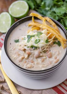 a white bowl filled with chicken chili and tortilla chips on top of a table