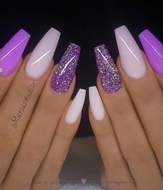 two hands with purple and white nail polishes on their nails, one is holding the other