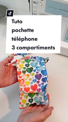 a person holding up a phone case in front of a sewing machine with the words tuto pochette telephone 3 compartments