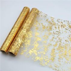 two rolled up gold glitter paper sitting on top of each other