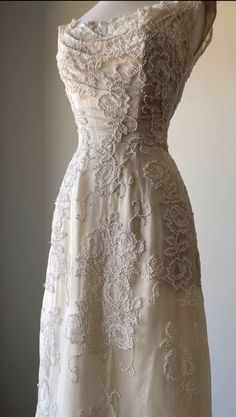 a white wedding dress on display in a room