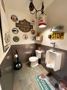 a bathroom with several signs on the wall and a toilet in the middle, along with other items